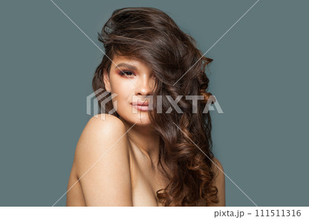 Attractive cheerful woman brunette with natural make-up, healthy clean fresh skin and dark wavy hair 111511316