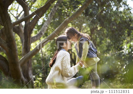 asian mother and daughter having a good time outdoors in park asian mother and daughter having a good time outdoors in park 111512831