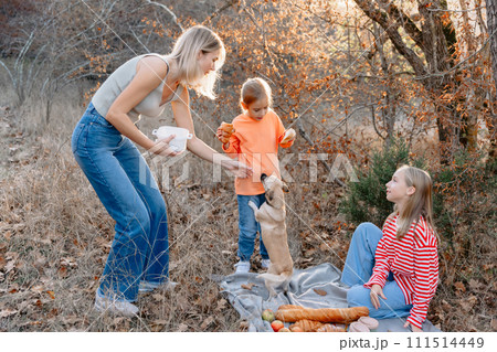 Mother with cute girls and dog relaxing on a picnic outdoor in forest Mother with cute girls and dog relaxing on a picnic outdoor in forest 111514449