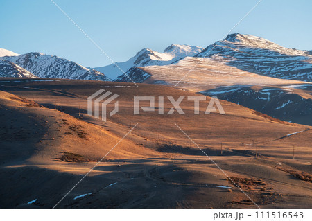 snowy mountain ridge illuminated by setting sun snowy mountain ridge illuminated by setting sun 111516543