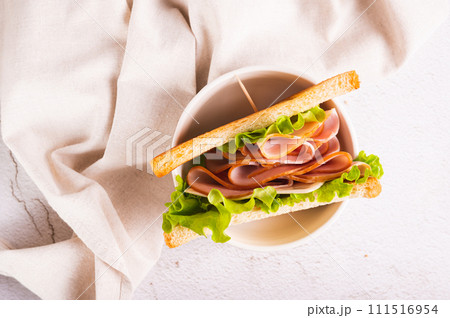 Close up of sandwich with ham, cheese and onion in a bowl on the table top view Close up of sandwich with ham, cheese and onion in a bowl on the table top view 111516954