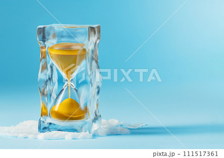 Hourglass in ice cube, frozen time. Stopping the time concept, freeze time, sand clock in ice, copy space. Climate change. Daylight saving time, save the date, fall back, spring forward. Hourglass in ice cube, frozen time. Stopping the time concept, freeze time, sand clock in ice, copy space. Climate change. Daylight saving time, save the date, fall back, spring forward. 111517361