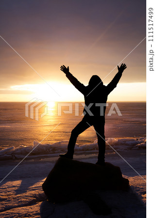 Man on rock on the sea in the ice - silhouette Man on rock on the sea in the ice - silhouette 111517499