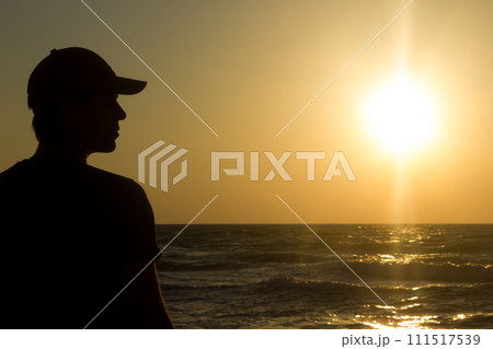 Portrait of a young man in cap on the beach Portrait of a young man in cap on the beach 111517539