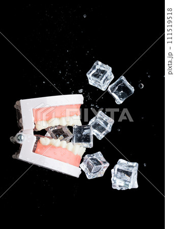 Artificial Tooth Plastic jaw decay sensitive with ice cube cold drink. Patient feel sensitive during drinking ice cold soft drink ice cream with Teeth of dental jaw model. Black background isolated 111519518