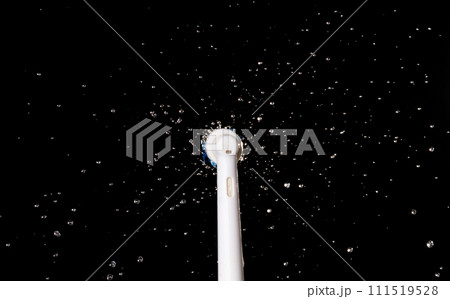 Electronic Brush spin with droplet splash around. Water Droplet splash all around electronic brush. Black background isolated, brush blur focus on water 111519528
