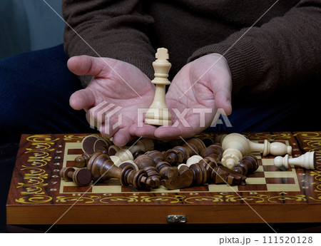 A chess piece in men's over the game board after the end of a game. A chess piece in men's over the game board after the end of a game. 111520128