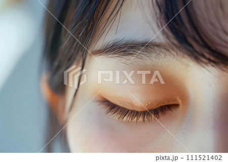 目を閉じるアジア人女性の目元ケア 111521402