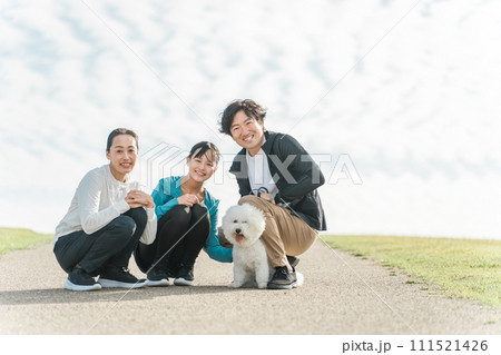 公園で犬の散歩をする愛犬家の家族・親子・ファミリー 公園で犬の散歩をする愛犬家の家族・親子・ファミリー 111521426