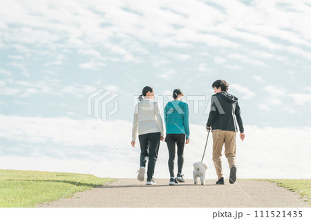 青空の見える公園で犬の散歩・運動・トレーニング・有酸素運動をするさわやかな家族・親子 青空の見える公園で犬の散歩・運動・トレーニング・有酸素運動をするさわやかな家族・親子 111521435