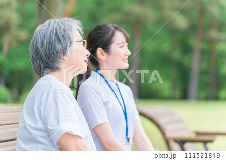 公園で話す高齢者と笑顔の介護スタッフの女性(話す・楽しい) 公園で話す高齢者と笑顔の介護スタッフの女性(話す・楽しい) 111521849