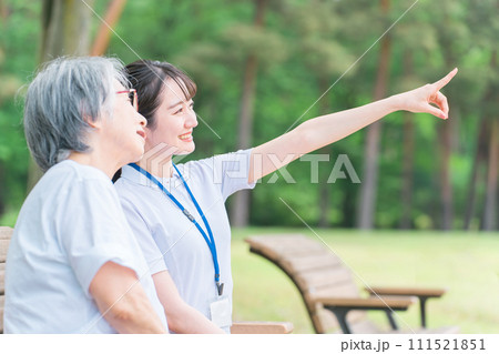 公園で話す高齢者と笑顔の介護スタッフの女性(話す・楽しい) 公園で話す高齢者と笑顔の介護スタッフの女性(話す・楽しい) 111521851