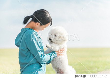 公園で犬と遊ぶ女の子・犬の散歩・運動 公園で犬と遊ぶ女の子・犬の散歩・運動 111522692