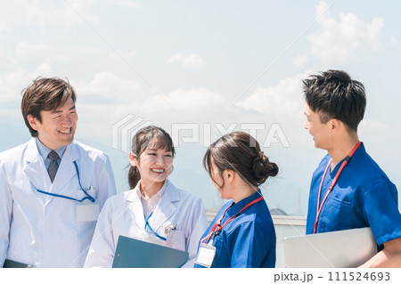 病院の屋上で休憩時間を過ごす男女の医師・医者・看護師・医療従事者・技師(4人) 病院の屋上で休憩時間を過ごす男女の医師・医者・看護師・医療従事者・技師(4人) 111524693