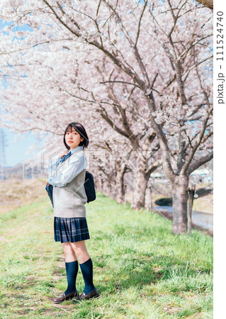 桜の咲いた河川敷を通学する女子高生 桜の咲いた河川敷を通学する女子高生 111524740