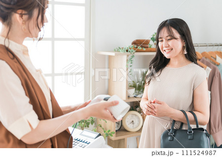 雑貨屋で食器・マグカップ・カップを買う女性（レジ・レジ打ち・POSレジ） 111524987