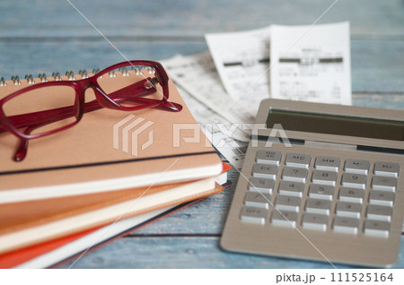 机の上のレシートとメガネと計算機とノート 机の上のレシートとメガネと計算機とノート 111525164