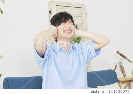 リビングで耳を塞ぐ男性 リビングで耳を塞ぐ男性 111526076