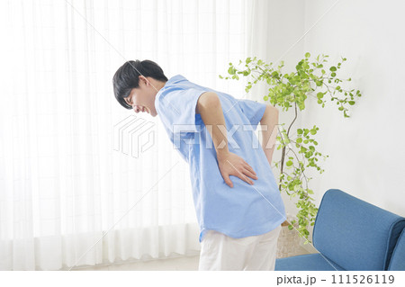 リビングでぎっくり腰で腰が痛い男性 111526119