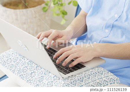 リビングでノートパソコンでを使う男性　顔無し 111526139