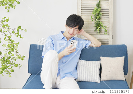 リビングでスマートフォンを使う男性 111526175