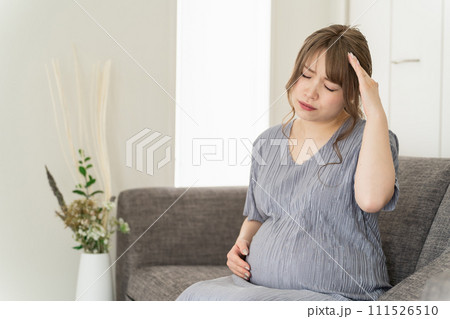 家のソファに座る妊婦・マタニティ(頭痛・風邪・妊娠後期) 家のソファに座る妊婦・マタニティ(頭痛・風邪・妊娠後期) 111526510