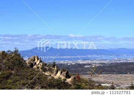 堂山の登山道にある大きな岩越しに見える比叡山と琵琶湖 111527781