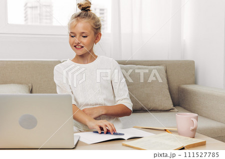 Online schoolgirl lesson homework education child couch school learning distance laptop 111527785