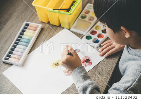 絵の具を使って白い紙に絵を描いている男の子 絵の具を使って白い紙に絵を描いている男の子 111528402