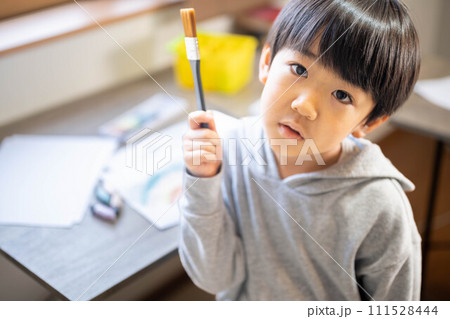 絵の具を使って白い紙に絵を描いている男の子 絵の具を使って白い紙に絵を描いている男の子 111528444