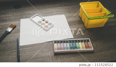 子どもが絵の具を使い白い紙に絵を描く様子 111528522