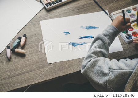 子どもが絵の具を使い白い紙に絵を描く様子 子どもが絵の具を使い白い紙に絵を描く様子 111528546