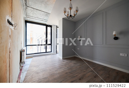Comparison of living room with large panoramic window before and after renovation. Photo collage of old apartment before restoration and new renovated flat with elegant interior design. 111529422