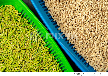 Pet litter tray with wooden filler on gray background Pet litter tray with wooden filler on gray background 111530460