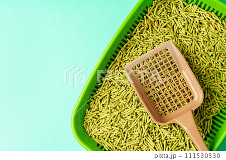 Pet litter box with bio filler on green background Pet litter box with bio filler on green background 111530530