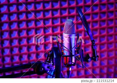 Professional studio microphone against acoustic foam panel background in neon light 111531214