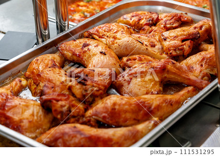 Metal tray with fresh baked chicken in a canteen 111531295