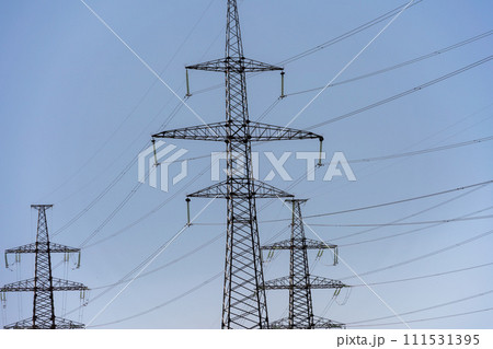 High voltage towers with sky background. Power line support with wires for electricity transmission. High voltage grid tower with wire cable at distribution station. Energy industry, energy saving High voltage towers with sky background. Power line support with wires for electricity transmission. High voltage grid tower with wire cable at distribution station. Energy industry, energy saving 111531395
