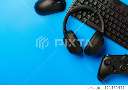 Computer keyboard and joystick on blue background top view 111531431