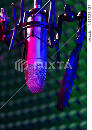 Professional studio microphone against acoustic foam panel background in neon light Professional studio microphone against acoustic foam panel background in neon light 111531432