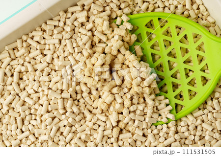 Wooden pet litter filler with scoop isolated on white background Wooden pet litter filler with scoop isolated on white background 111531505
