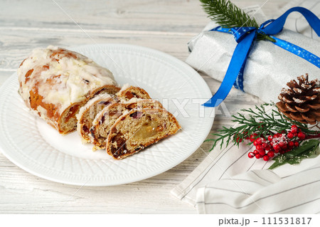 Christmas stollen on plate on white wooden table Christmas stollen on plate on white wooden table 111531817