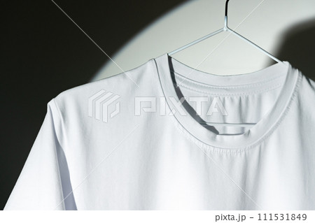 Blank T-shirt hanging in a spotlight in studio Blank T-shirt hanging in a spotlight in studio 111531849