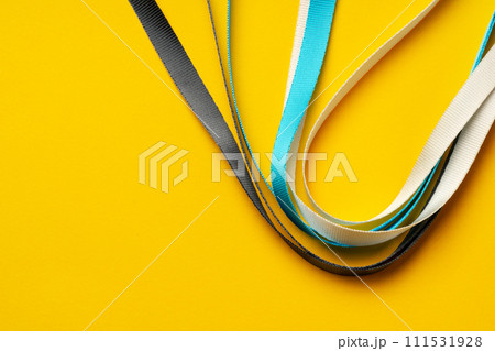 Badge strings on yellow background close up 111531928
