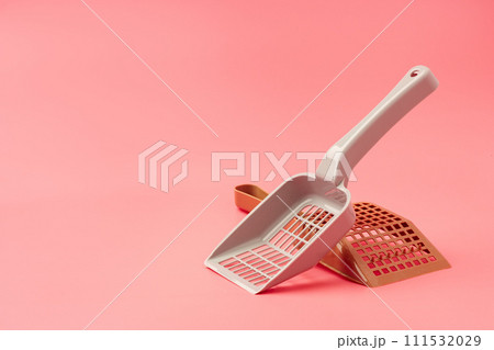Plastic pet scoop on pink background close up 111532029