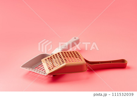 Plastic pet scoop on pink background close up 111532039