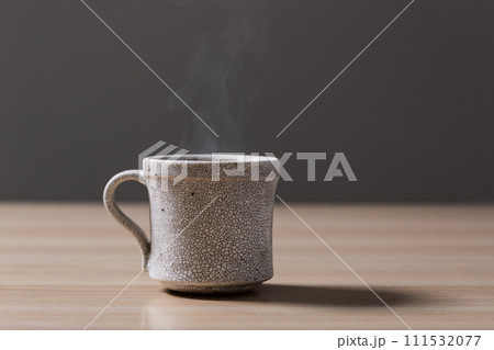 テーブルの上に置かれた湯気のたつコーヒー テーブルの上に置かれた湯気のたつコーヒー 111532077