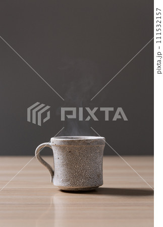 テーブルの上に置かれた湯気のたつコーヒー テーブルの上に置かれた湯気のたつコーヒー 111532157