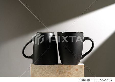 Black cup shadow sun light against gray background Black cup shadow sun light against gray background 111532713