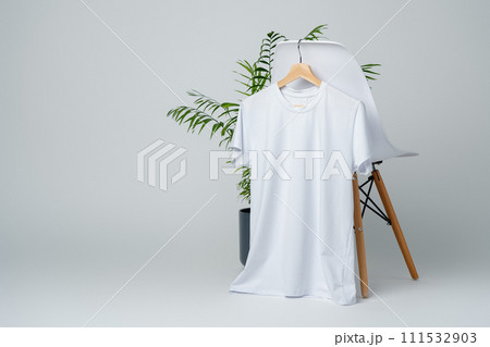 Blank white T-shirt hanging on a chair on white background Blank white T-shirt hanging on a chair on white background 111532903